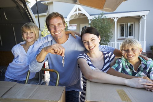 Trained removal workers carrying furniture with care in a London property