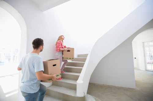 Removal workers communicating while carrying furniture safely