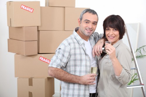 Staff using safe lifting methods and moving tools during a house move